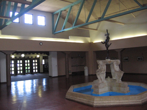 Inside the Balboa Park Club's grand foyer, looking back toward the entrance. At the center stands the Four Cornerstones of American Democracy, a 1935 sculpture by Frederick Schweigardt.