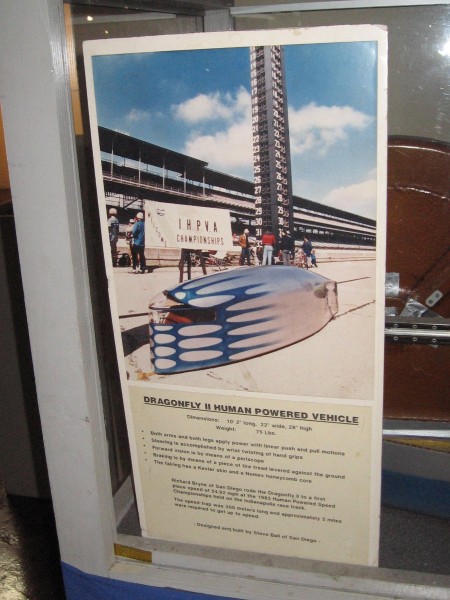 Sign describes the Dragonfly II. Richard Byrne of San Diego rode it to a first place finish at the 1983 Human Powered Speed Championships held on the Indianapolis race track.